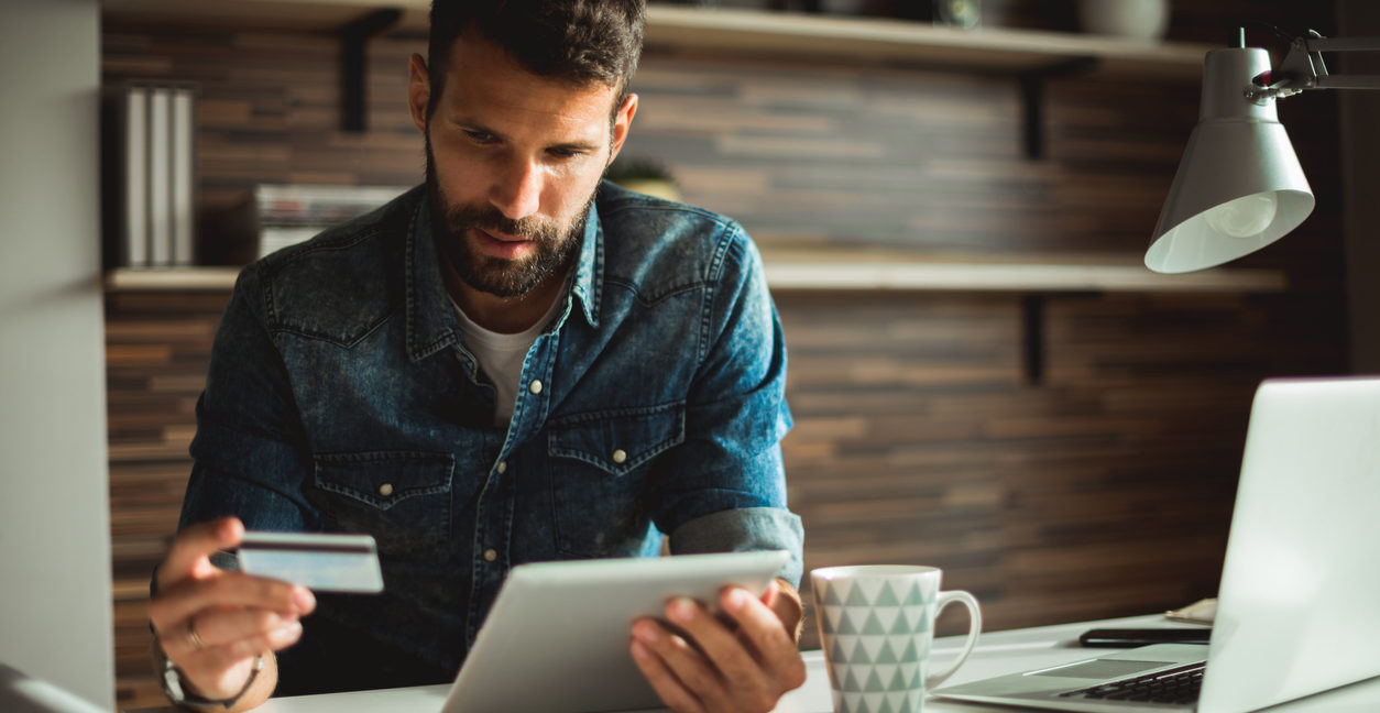 Man looking at a tablet and a credit card