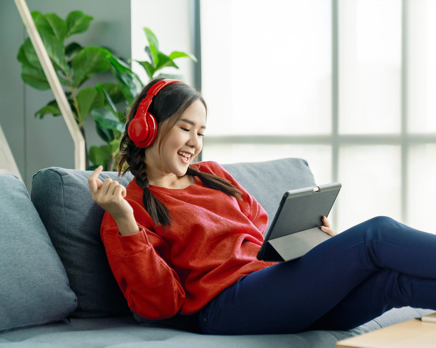 A woman wearing headphones and using a tablet